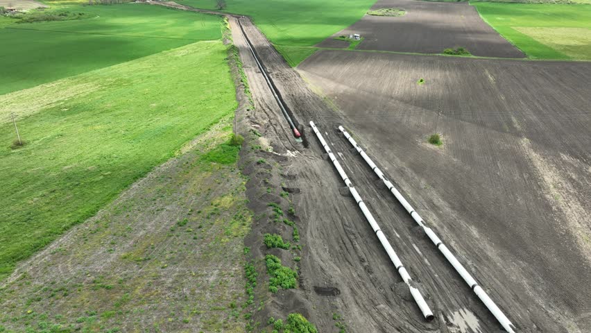 Aerial view of gas and oil pipeline construction. Pipes welded together. Big pipeline is under construction.