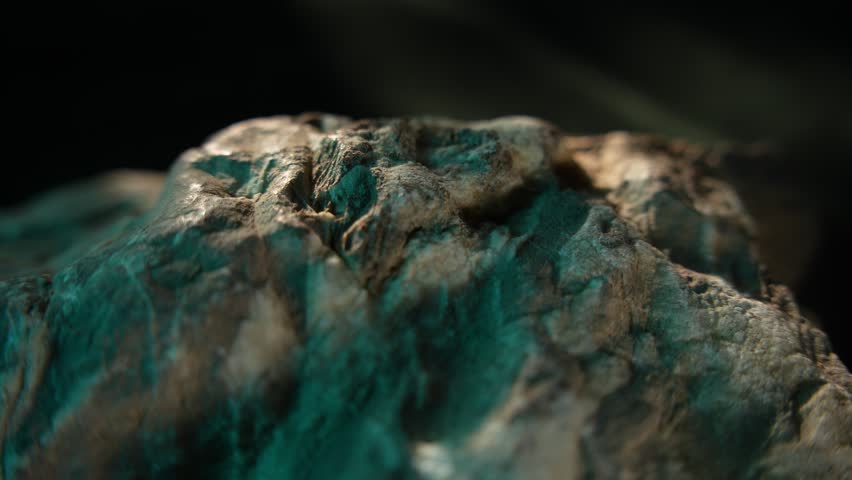 Close-up rock surface with green tones and flowing texture