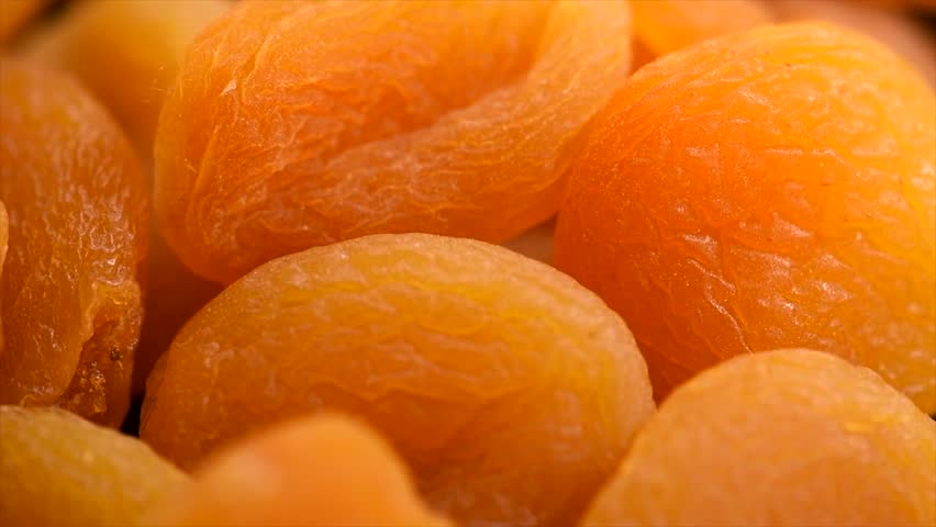 Dried apricots background close-up. Apricot fruits. Ripe Organic Apricots fruit rotating backdrop. Close up. Heap of dried apricot background, vegan food, top view. 