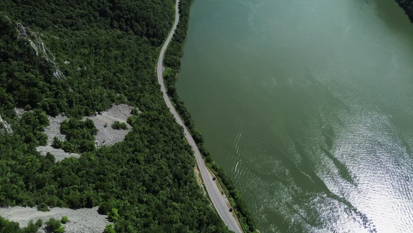 4k aerial footage of the Djerdap Gorge, also known as the Iron Gate, in Serbia. The Danube River flows between Serbia and Romania through green spring mountains