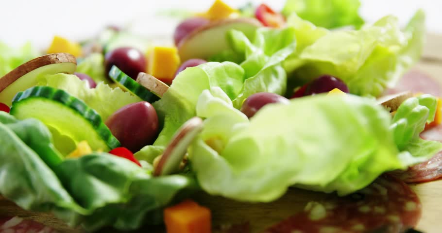Social badges appearing over salad after gray sub badge appearing, camera pulling focus, engaging. Greens, cucumber, olives, mushrooms, cheese, closeup, macro