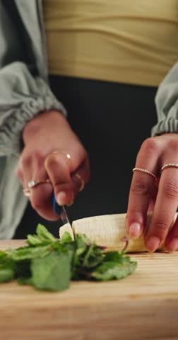 Person, hands and chopping with banana in kitchen for fruit smoothie, meal prep or detox in home. Nutritionist, diet or cutting with natural organic food for potassium, nutrition or vitamins on board