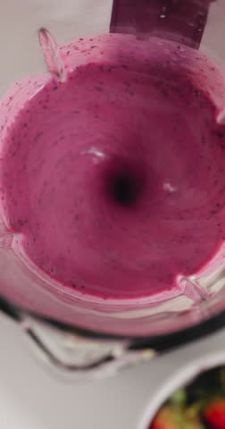Above, blender and hands in kitchen for smoothie, wellness benefits and fruit for detox in home. Person, appliance and liquid with organic ingredients, strawberry or banana for nutrition at apartment
