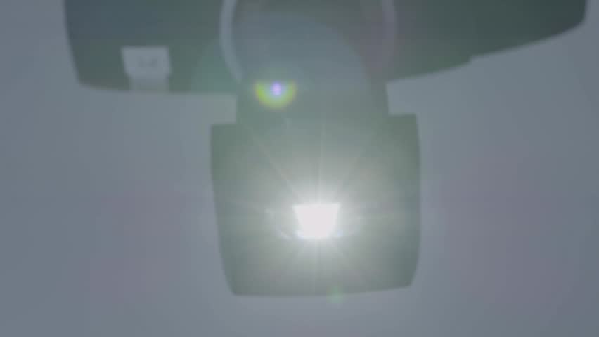Bright midday sun shines in clear sky with visible lens flare and slight haze