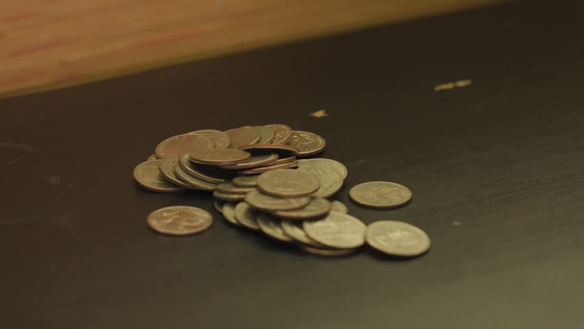 Focus pulling in and out over a pile of quarters.