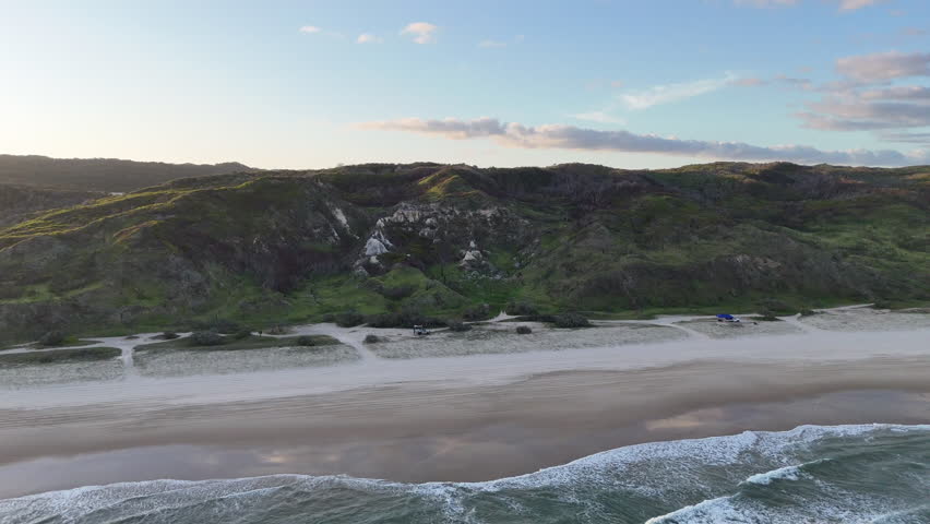 Aerial drone view of white sand beach at sunset on Fraser Island K gari, Queensland, Australia. Turquoise water, tropical coast, popular off-road and travel destination.