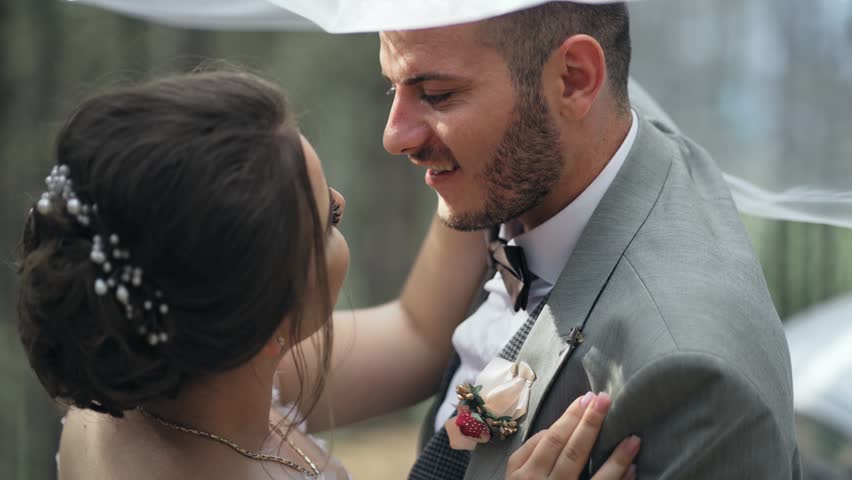 Romantic groom and bride kiss embracing during an intimate wedding ceremony