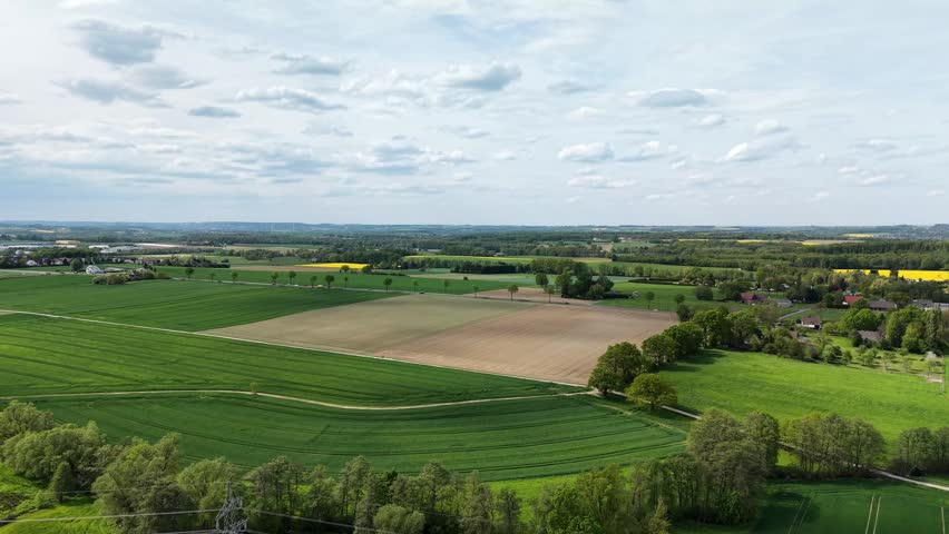Beautiful aerial view of green agricultural fields and a vast rural landscape under a cloudy sky