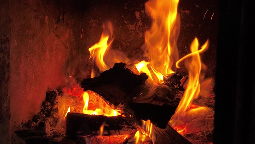 Strong fire consuming wooden logs in fireplace, vivid flame and dynamic blaze spreading heat and warmth indoors, closeup detail of natural fire texture on dark background, modern comfort concept