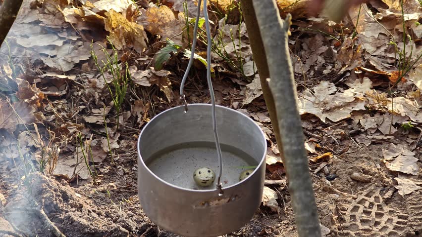 Traditional cooking in a pot over a dakota fire hole in the forest