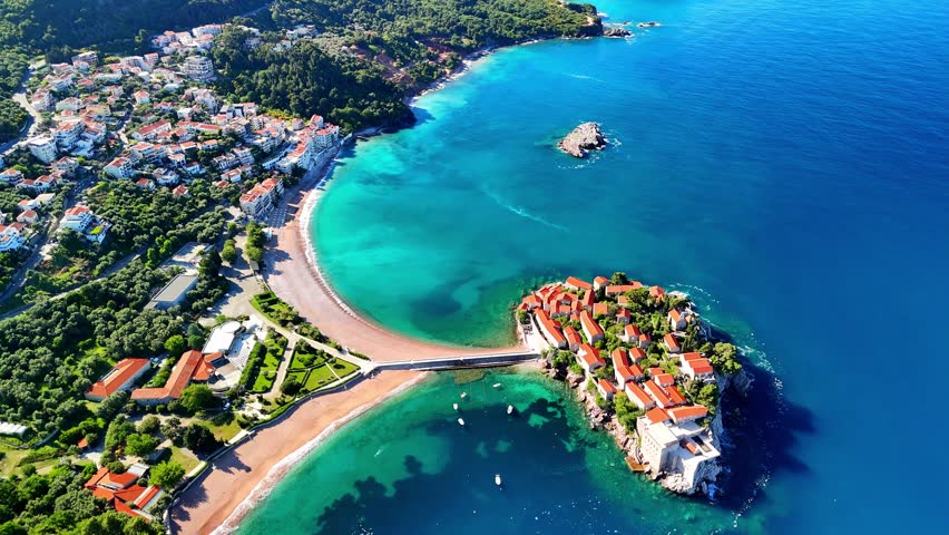Aerial drone view of the beach and Sveti Stefan Island. Beautiful architecture and the blue Adriatic Sea. Sveti Stefan, Montenegro.	
