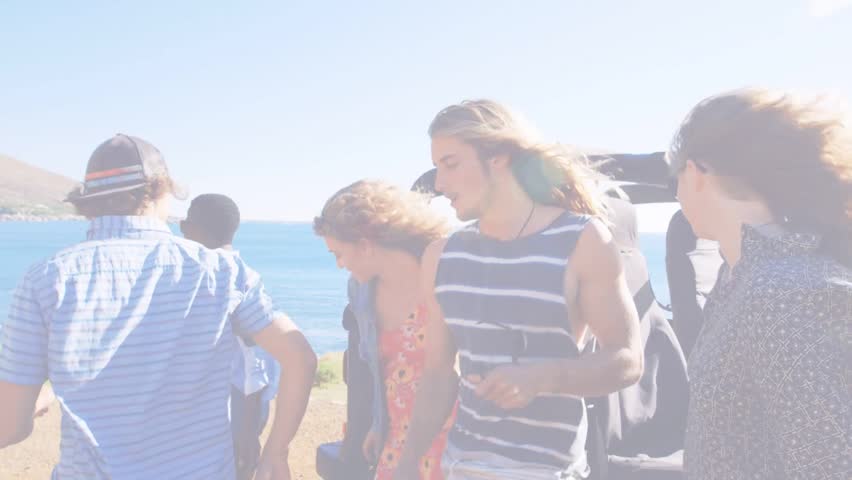 Grabbing gear, person starting group walking toward cliff, travel ad showing drifting hearts. Petal, pink, convertible, coastal, overlook, wind, breeze
