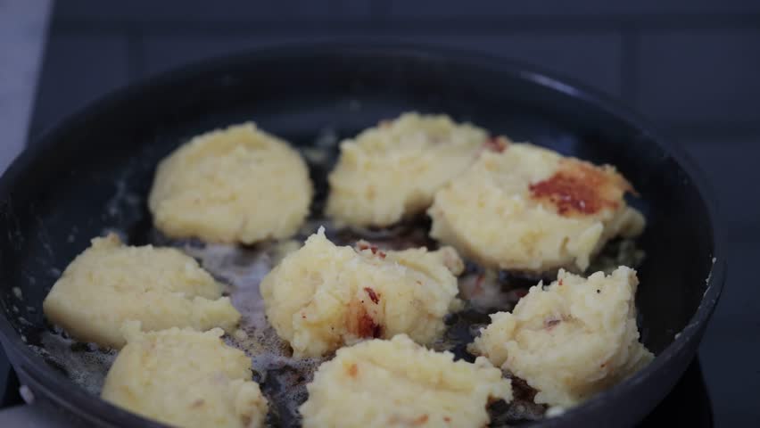 Stockholm, Sweden A cook makes fried mashed potato patties in a frying pan. 