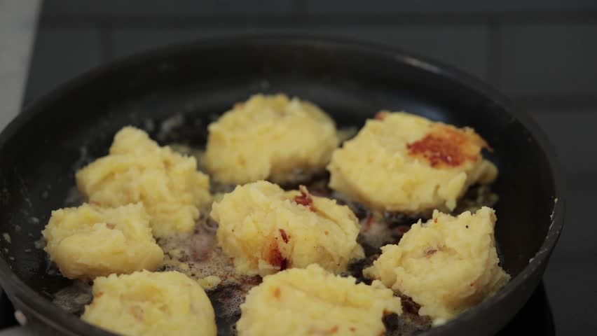 Stockholm, Sweden A cook makes fried mashed potato patties in a frying pan. 