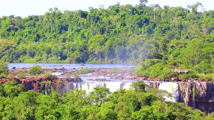 Foz do Iguacu Iguazu Falls waterfall fall waterfalls cascade cascades in tropical nature rainforest panorama view with blue sky and turquoise green water in Parana Brazil and Misiones Argentina.