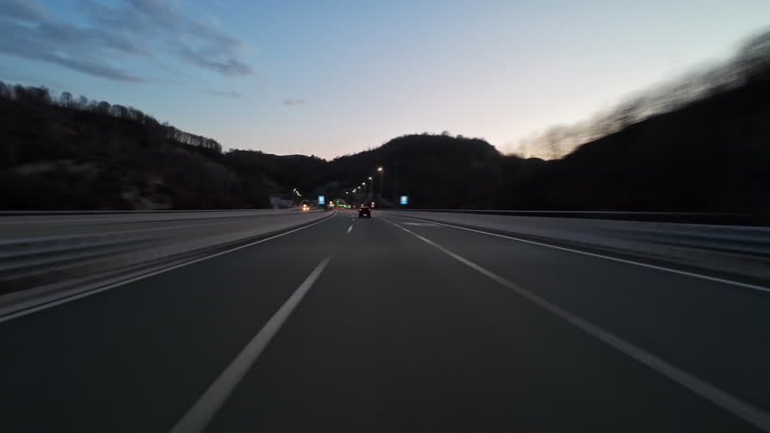 POV fast driving on modern highway and inside tunnel with bright lights illuminating road at night. Transportation and travel concept, 4k