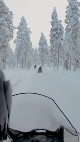 Explore the stunning winter landscape of Akaslompolo in Lapland, Finland, as snowmobiles glide through enchanting white forests. Experience the thrill and beauty of this serene setting.