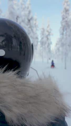 Journey through a breathtaking snowy landscape in Akaslompolo, Lapland. Explore the enchanting winter forest as snowmobiles glide on soft white trails surrounded by tall, frosty trees.