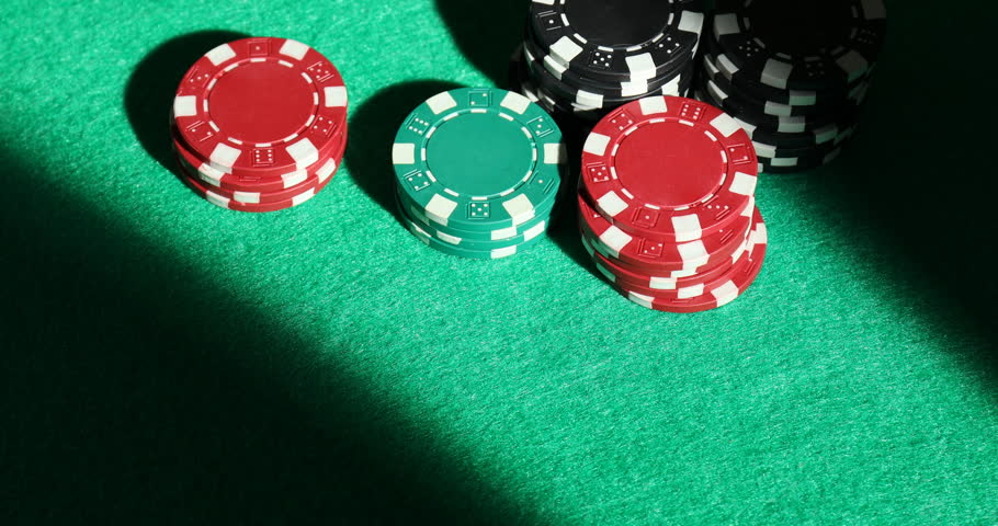 Casino chips and playing cards on green table