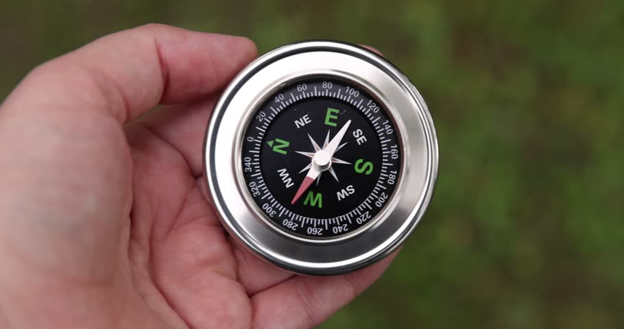 Man with compass outdoors, above view. Camera tracking