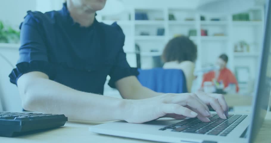 Woman typing on laptop in open-plan office, initiating HUD overlays and analyzing finance charts. Data, analytics, dashboard, monitor, collaboration, teamwork, workspace