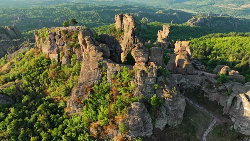 Scenic drone panorama historic Belogradchik Fortress unique red rocks Bulgaria. Sunny summer day Balkan mountains scenic landscape heritage travel tourism destination exploration.