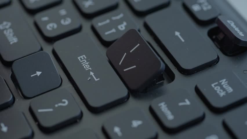 Macro keyboard key removal using tool with steady hands, metal stabilizer exposed, careful lift of Enter keycap, neat office workspace, instructional repair sequence.