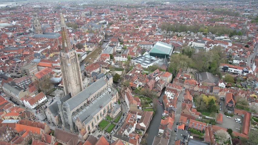 Aerial drone footage of the iconic Onze-Lieve-Vrouwekerk church in the famous Belgian historical city of Bruges, Belgium
