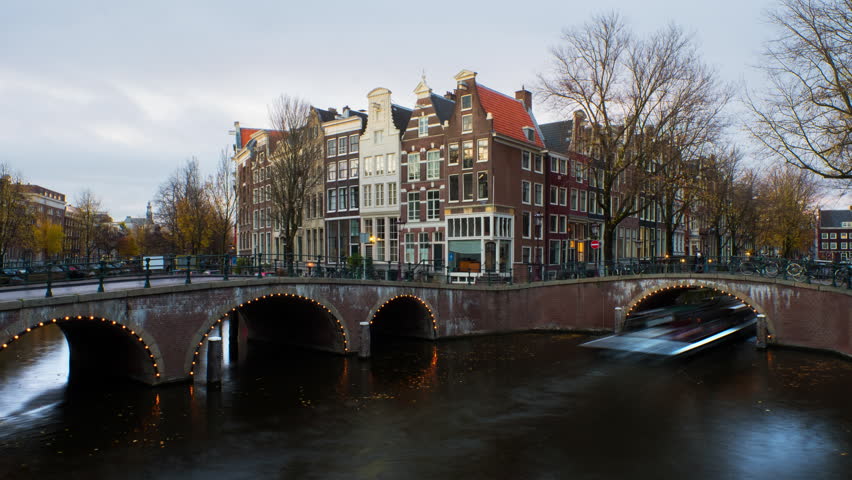 Amsterdam, Netherlands. Night view of canals and bridges in Amsterdam, Netherlands. Time-lapse of Keizersgracht and famous touristic place at sunset with illuminated houses