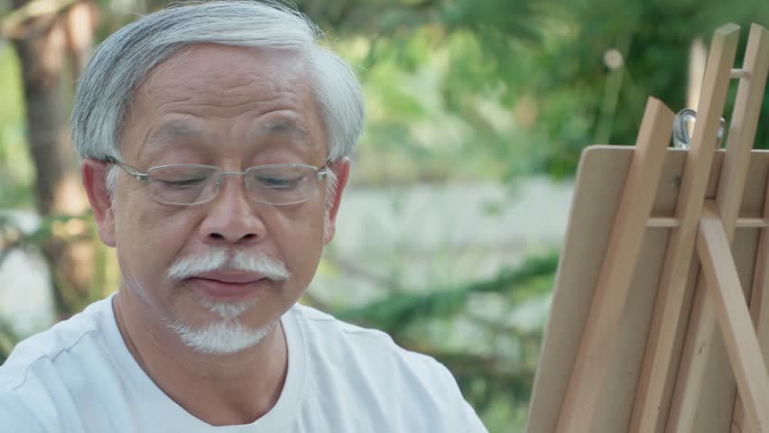 Artistic Inspiration: An elderly artist, lost in concentration, meticulously paints on a canvas outdoors, surrounded by nature