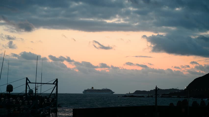 A large cruise ship sailing towards the harbor in Keelung, Taiwan, during a peaceful spring dawn with soft pastel clouds in the sky.