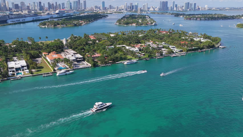 Motorboat floating sea passing residential buildings in luxury Star island surrounded by sea. Waterfront residential area on Star island, Miami. Florida landscape. Star Island in Miami beach, Florida
