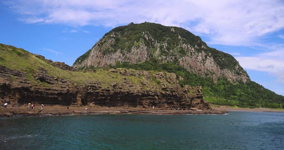 Yongmeori Coast, Jeju Island, South Korea, Yongmeorihaean Coast with Sanbangsan volcano mountain in the background, landscape in a sunny day, Seogwipo, coastal walk trail with rocky shore, Jeju-do