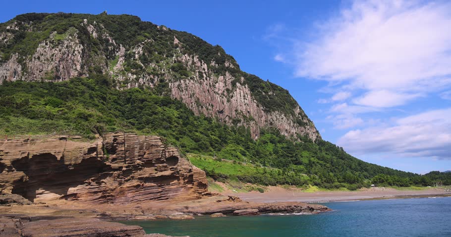 Yongmeori Coast, Jeju Island, South Korea, Yongmeorihaean Coast with Sanbangsan volcano mountain in the background, landscape in a sunny day, Seogwipo, coastal walk trail with rocky shore, Jeju-do