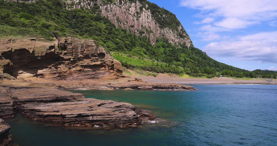 Yongmeori Coast, Jeju Island, South Korea, Yongmeorihaean Coast with Sanbangsan volcano mountain in the background, landscape in a sunny day, Seogwipo, coastal walk trail with rocky shore, Jeju-do