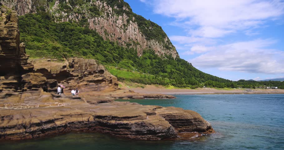Yongmeori Coast, Jeju Island, South Korea, Yongmeorihaean Coast with Sanbangsan volcano mountain in the background, landscape in a sunny day, Seogwipo, coastal walk trail with rocky shore, Jeju-do