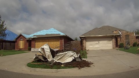 MOORE, OK - MAY 20, 2013: This was a neighborhood in Moore, Oklahoma after the EF5 tornado hit on May 20, 2013.  Houses are turned to ruble.  Destroyed cars litter the street and yards.  Trees are stripped of leaves and bark.