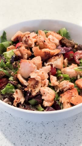 Close -Up of a Salmon Salad , in a white bowl. 