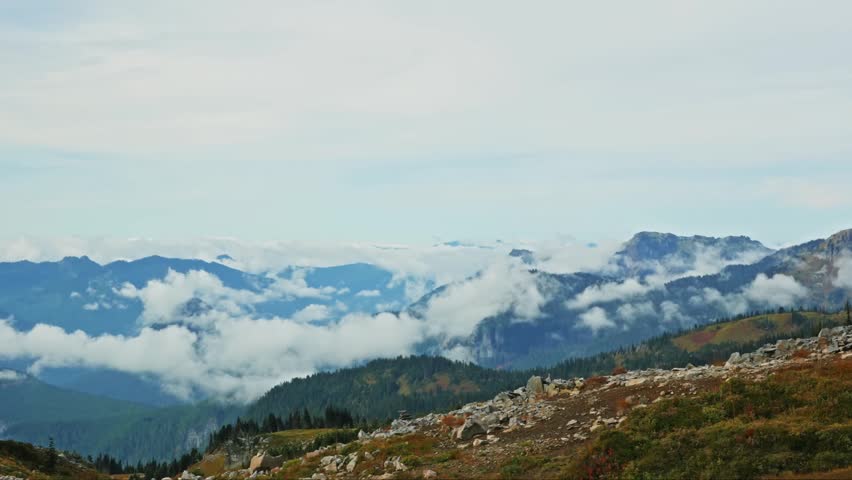 panoramic view of the rugged Cascade Mountains from Panorama Point, a popular viewpoint on the Skyline Trail in Mount Rainier National Park, Washington State. The footage captures a vast wilderness of