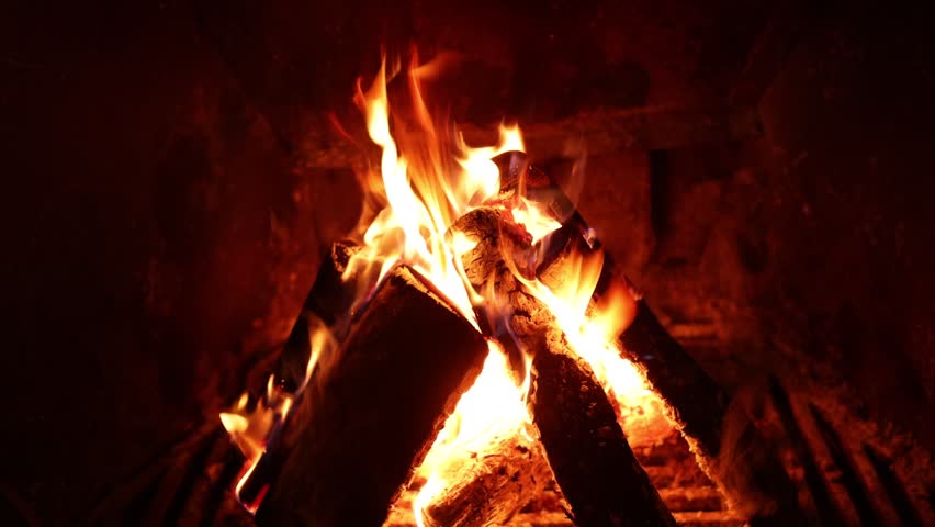 Wood burning in fireplace at home, closeup