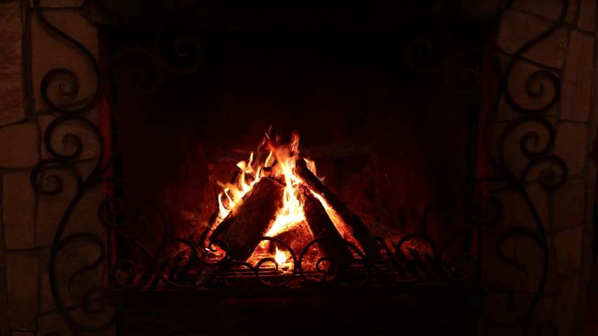 Wood burning in fireplace at home. Cozy atmosphere