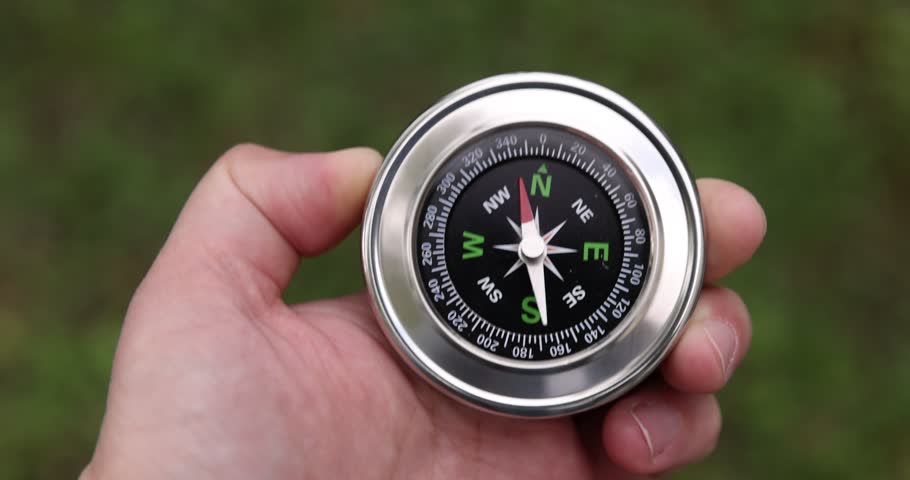 Man with compass outdoors, above view. Camera tracking