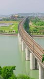 Two modern high-speed trains pass each other in opposite directions on the railway bridge over the river. - Powered by Shutterstock - Get 15% off with code: PIKWIZARD15