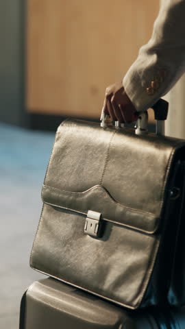 Arrival, hand and luggage with business man in office for international travel or trip. Entrance, suitcase and walking with employee in corporate workplace for career development or opportunity