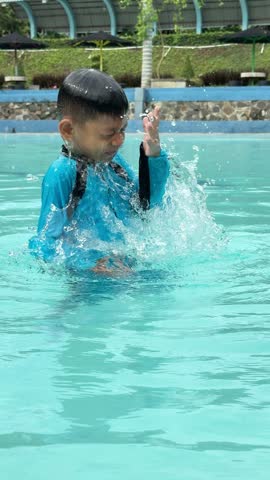 Cute and happy asian boy swimming in the swimming pool