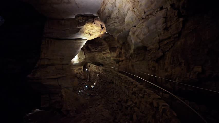 Underground trail winds through cave chambers with stalactites and stalagmites in Carlsbad Caverns National Park New Mexico