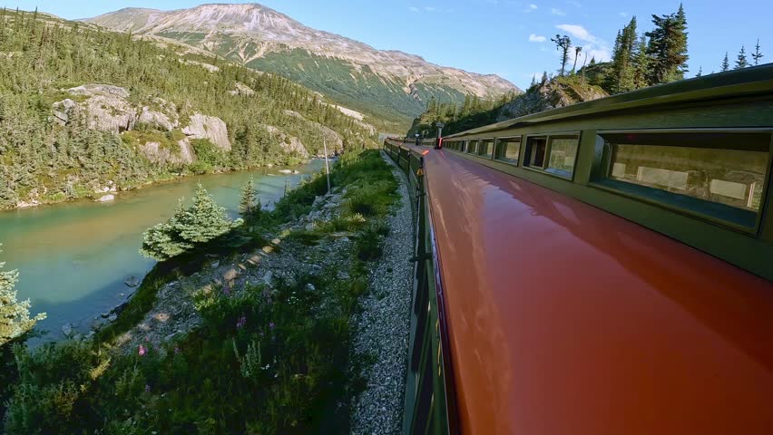 White Pass train ride between Skagway Alaska and Whitehorse Yukon Canada. Beautiful sunny day with white clouds and blue sky