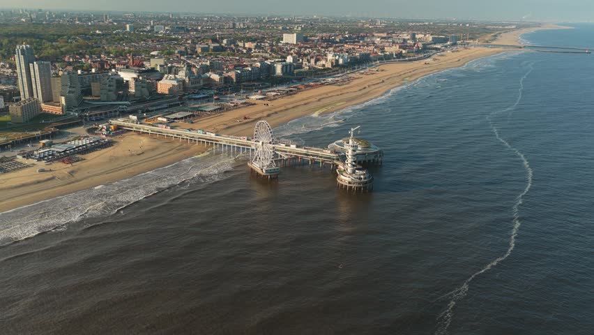 Aerial view of De Pier with its iconic ferris wheel and tower stretching into the North Sea along the Scheveningen beach in Den Haag, Zuid-Holland, Netherlands.
