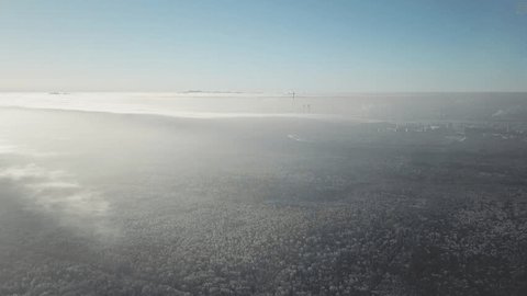 Aerial View of Snowy Forest Near Distant City