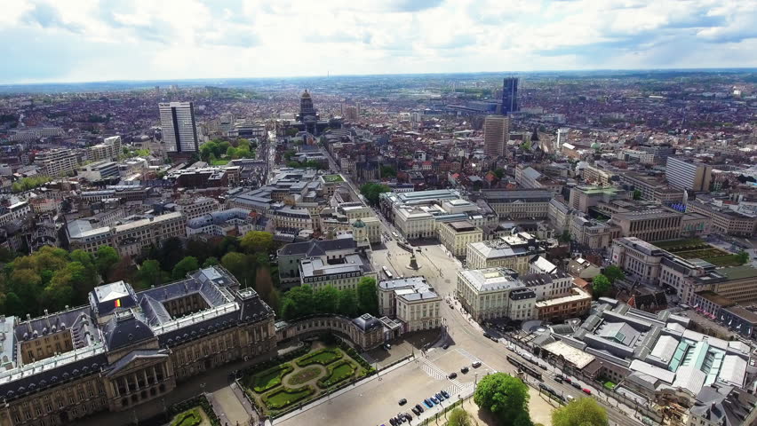 4K aerial view of the Royal Palace of Brussels, Brussels Park, Place des Palais and the Palace of Justice dome with cityscape stretching to the horizon. Belgian capital from above.

